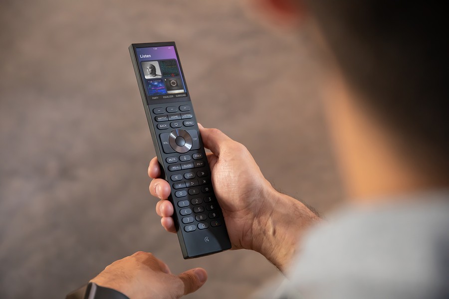 Closeup of a man using a Control4 smart remote.