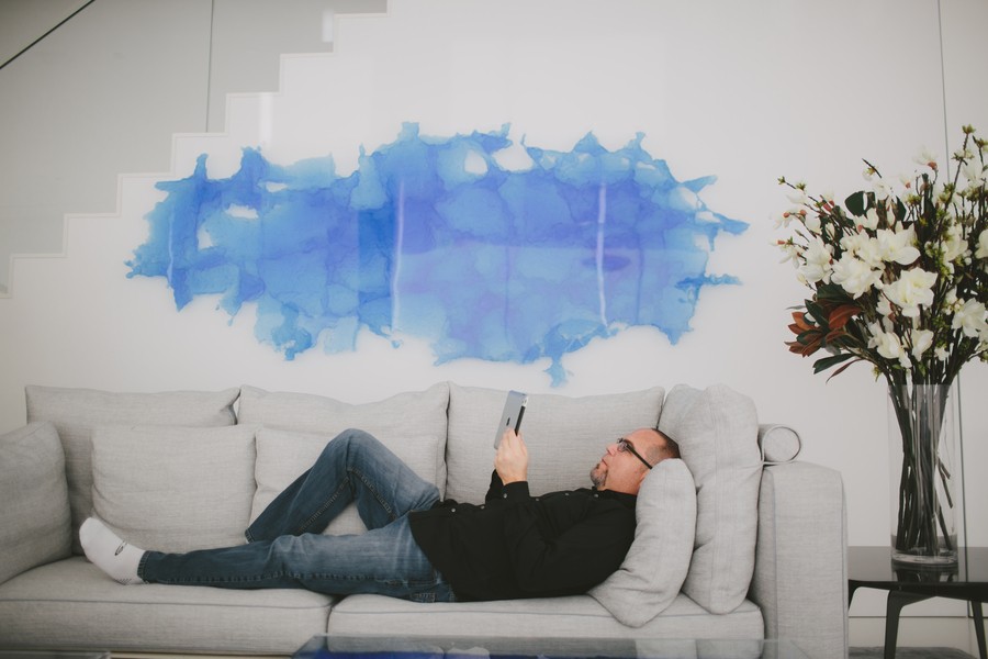 a person lying on a white couch using an iPad