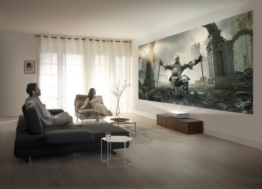Two people watching a movie via a Samsung short throw projector.