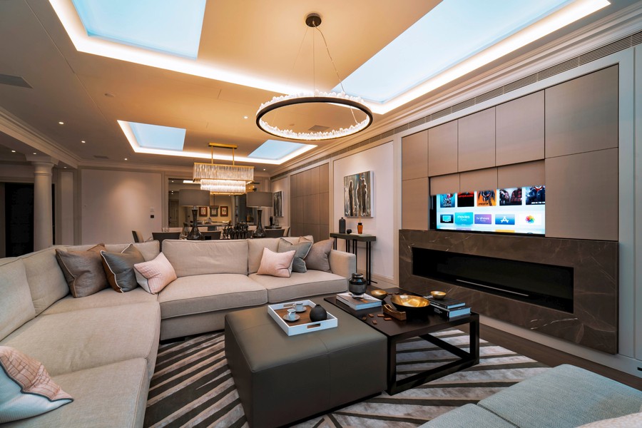 A modern living room with a wall panel rising to reveal a TV.